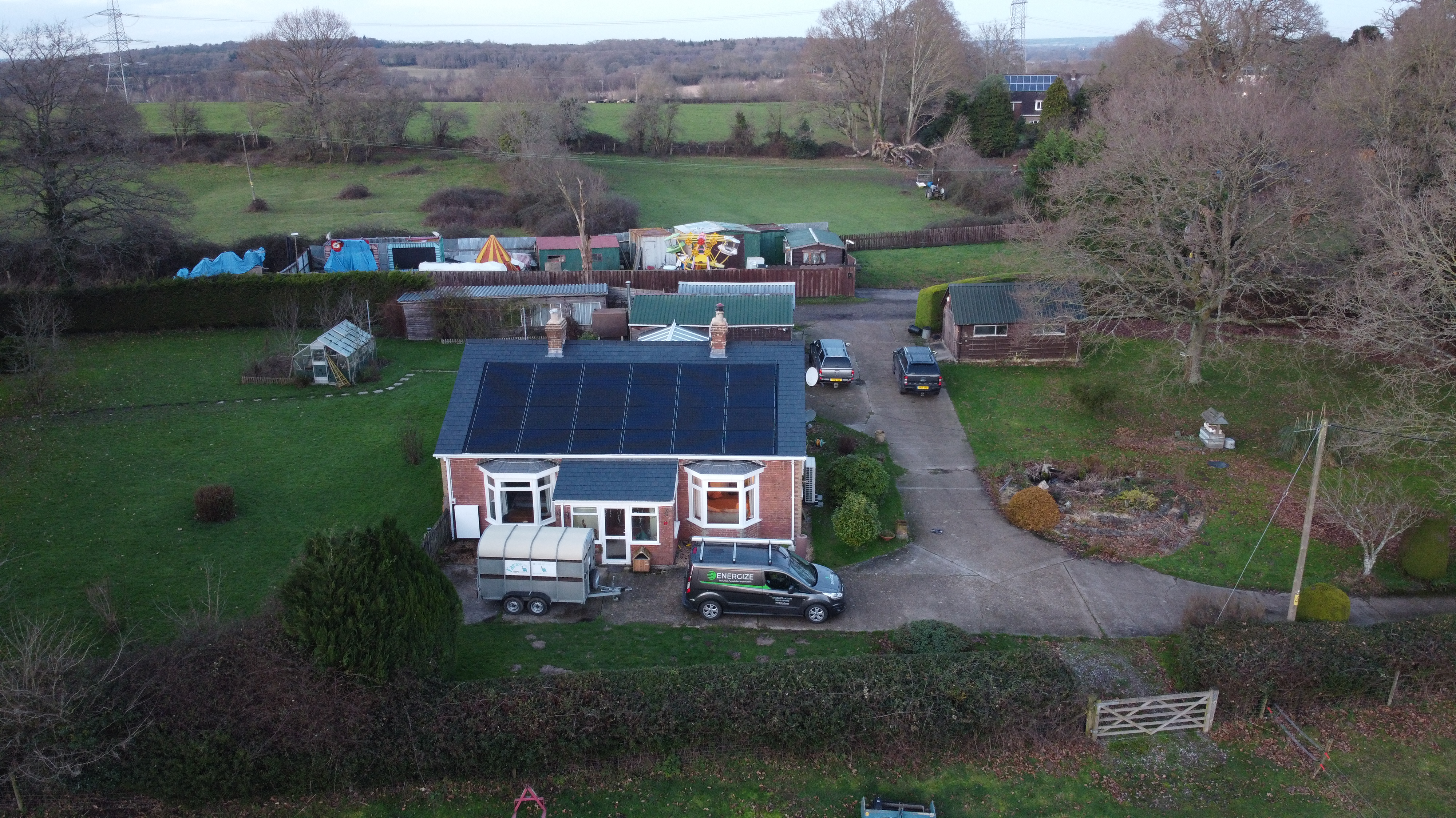 Aerial view of solar installation on rural bungalow with Energize van
